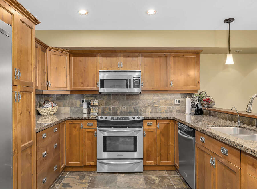 This stunning kitchen boasts custom wooden cabinetry, offering ample storage and a warm, inviting atmosphere.