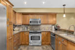 This stunning kitchen boasts custom wooden cabinetry, offering ample storage and a warm, inviting atmosphere.