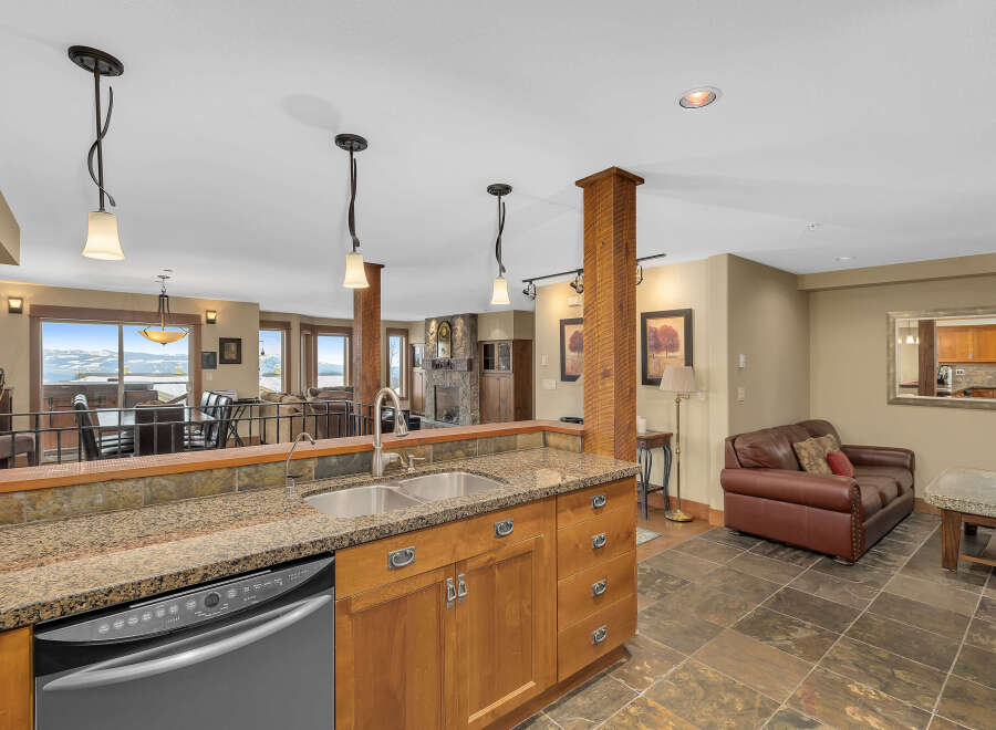 This stunning kitchen boasts a beautiful granite countertop, stainless steel sink, and modern appliances.