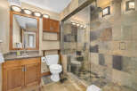Step into luxury with this stunning bathroom featuring a spacious walk-in shower with a glass door and elegant stone tile.