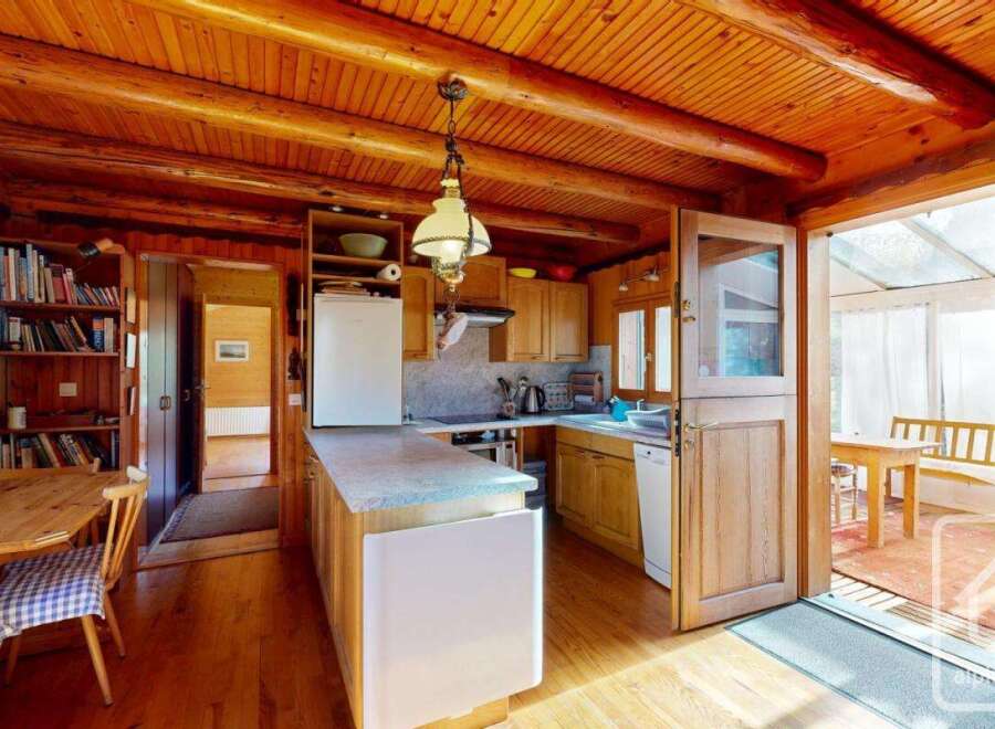 Step into this charming property featuring a rustic kitchen with wooden cabinetry and a cozy dining area.