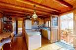 Step into this charming property featuring a rustic kitchen with wooden cabinetry and a cozy dining area.
