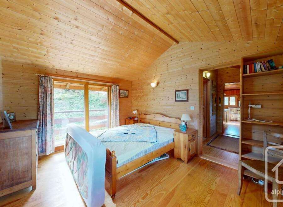Step into this charming bedroom, featuring warm wooden walls and ceilings that create a cozy atmosphere.