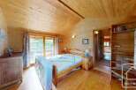 Step into this charming bedroom, featuring warm wooden walls and ceilings that create a cozy atmosphere.