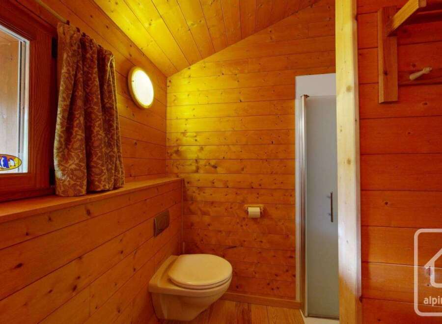 This charming bathroom features warm wooden paneling, creating a cozy and inviting atmosphere.