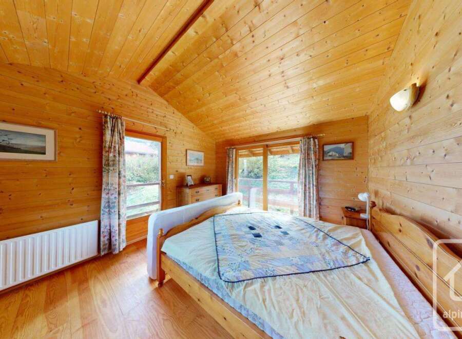 Step into this charming bedroom, where natural wood paneling creates a warm and inviting atmosphere.