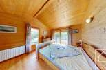 Step into this charming bedroom, where natural wood paneling creates a warm and inviting atmosphere.