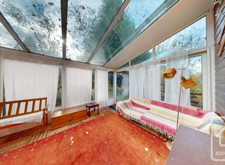 Discover a sun-drenched haven with this stunning property, featuring a unique glass-roofed sunroom.