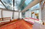 Discover a sun-drenched haven with this stunning property, featuring a unique glass-roofed sunroom.