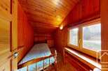 This cozy bedroom features warm wooden paneling throughout, creating a rustic and inviting atmosphere.