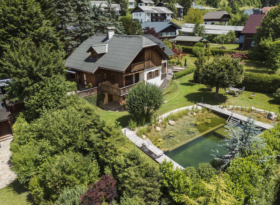 Discover your dream home in this stunning property! This luxurious house boasts a beautiful wooden exterior, a charming balcony, and a serene pond.
