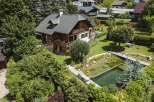 Discover your dream home in this stunning property! This luxurious house boasts a beautiful wooden exterior, a charming balcony, and a serene pond.