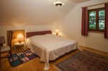 This cozy bedroom features a comfortable bed with a soft white coverlet, perfect for a relaxing retreat.