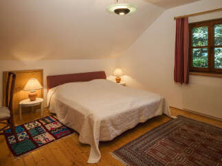 This cozy bedroom features a comfortable bed with a soft white coverlet, perfect for a relaxing retreat.