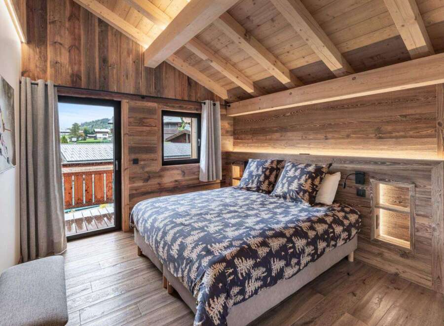 Experience rustic charm in this cozy bedroom, featuring stunning wood paneling and a vaulted ceiling.
