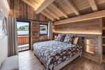 Experience rustic charm in this cozy bedroom, featuring stunning wood paneling and a vaulted ceiling.
