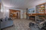 Step into this inviting living space, featuring a cozy fireplace and a stunning stone facade.