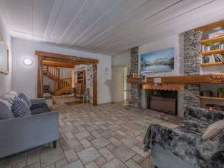 Step into this inviting living space, featuring a cozy fireplace and a stunning stone facade.