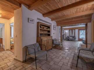 Step into this inviting home featuring a warm, wooden ceiling and a cozy seating area.