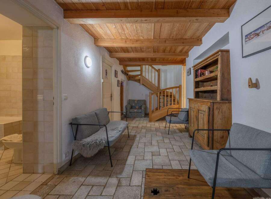 Step into this inviting entryway, featuring a stunning wooden ceiling and a unique stone tile floor.