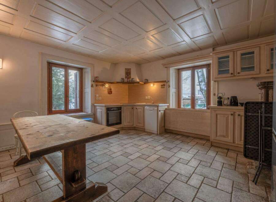 Step into this charming kitchen, featuring a rustic wooden table and a cozy atmosphere.