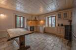 Step into this charming kitchen, featuring a rustic wooden table and a cozy atmosphere.