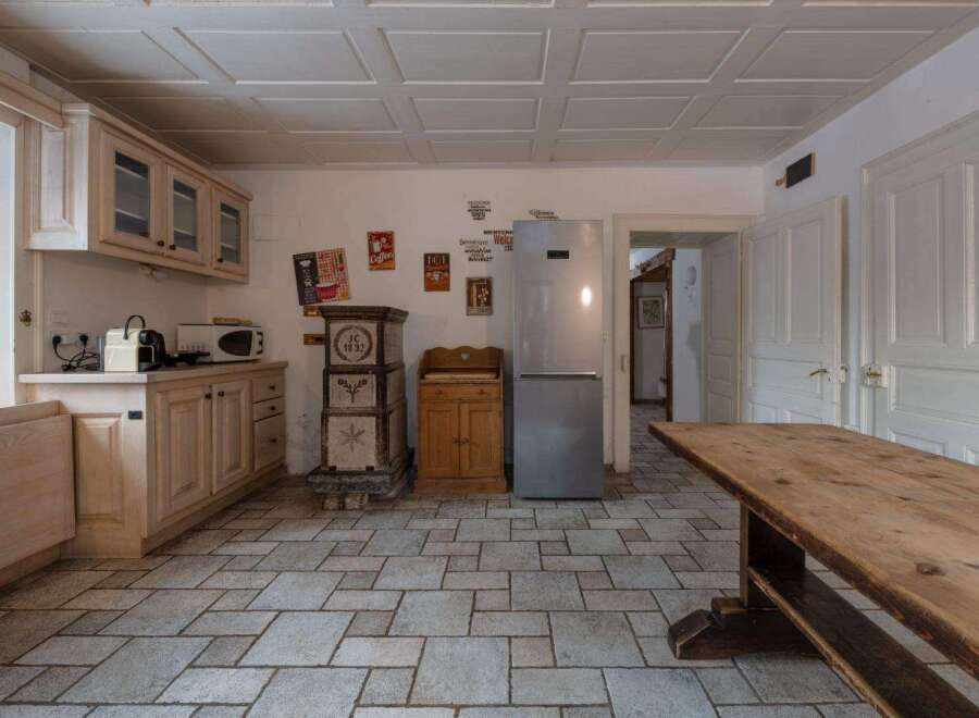 This charming kitchen features a rustic design with wooden cabinets and a large wooden table, perfect for family gatherings.