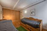 This charming bedroom features beautiful wooden accents, including a large sliding door closet and a pair of cozy beds.
