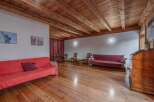 Step into this inviting living space, featuring a warm wooden ceiling and flooring that exudes rustic charm.