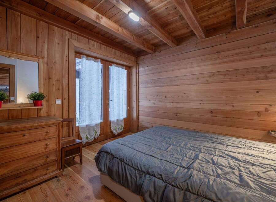 This charming bedroom features a rustic wooden interior, creating a warm and inviting atmosphere.