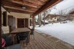 Enjoy the crisp mountain air from this charming covered porch, complete with a rustic wooden table and chairs, perfect for al fresco dining or morning coffee.