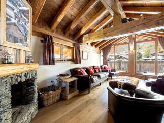 Experience the charm of this cozy mountain retreat, featuring a stunning stone fireplace and exposed wooden beams that create a warm and inviting atmosphere.