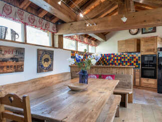 This charming property boasts a rustic dining area with a large wooden table and benches, perfect for gatherings.