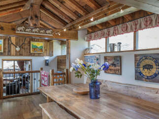 Step into rustic elegance with this stunning property, showcasing a beautifully crafted wooden dining area.
