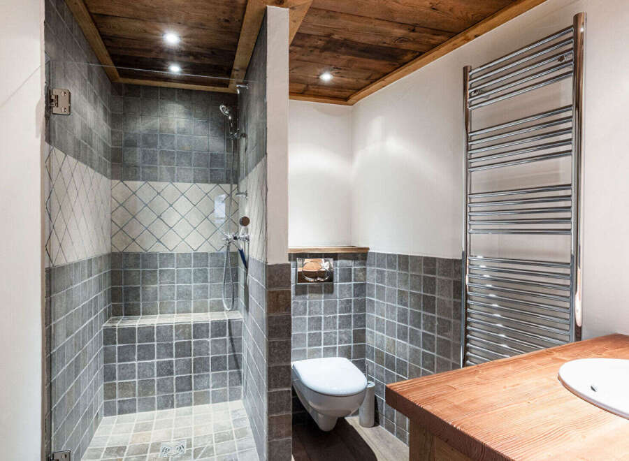 This stunning bathroom features a luxurious walk-in shower with elegant tile work and a wooden ceiling, creating a spa-like atmosphere.