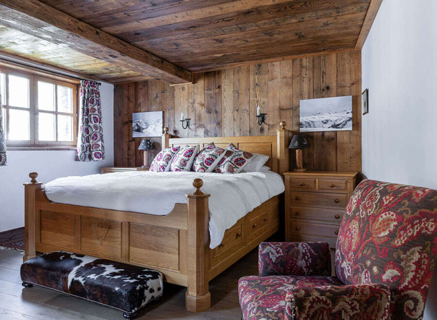 This cozy bedroom features a rustic wooden ceiling and walls, creating a warm and inviting atmosphere.
