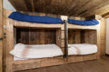 Discover the charm of this unique bunk bed setup, perfect for a cozy cabin or a stylish guest room.