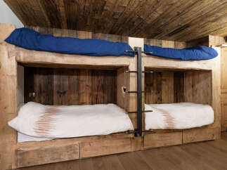 Discover the charm of this unique bunk bed setup, perfect for a cozy cabin or a stylish guest room.