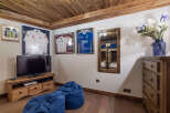 This cozy room features a rustic wooden ceiling and flooring, creating a warm and inviting atmosphere.