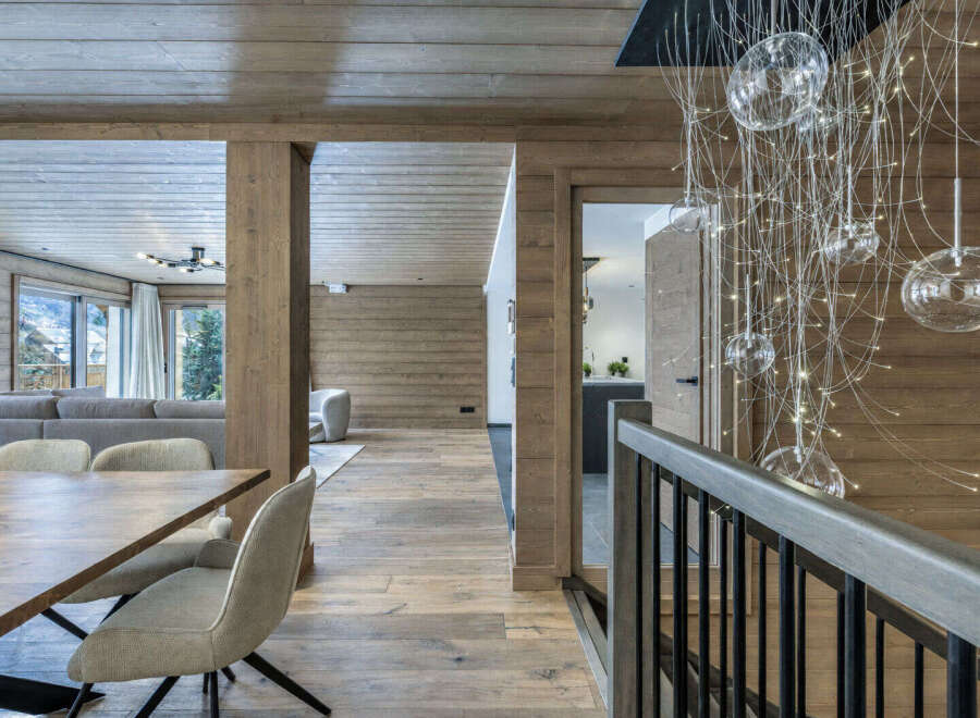 Experience luxurious mountain living in this stunning chalet, featuring a warm and inviting open-plan living area with a cozy dining space perfect for gatherings.