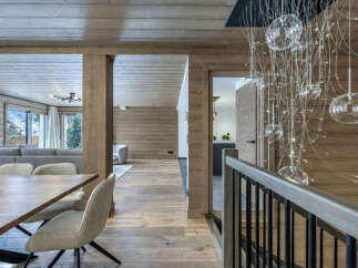 Experience luxurious mountain living in this stunning chalet, featuring a warm and inviting open-plan living area with a cozy dining space perfect for gatherings.