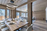 Experience luxurious mountain living in this stunning dining area, featuring a live-edge wooden table perfect for gatherings.