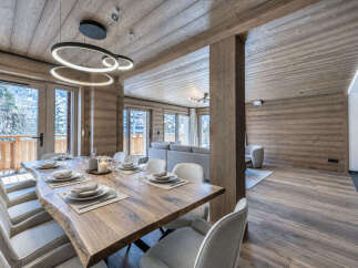 Experience luxurious mountain living in this stunning dining area, featuring a live-edge wooden table perfect for gatherings.
