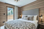 Experience luxurious mountain living in this beautifully appointed bedroom, featuring a plush king-size bed adorned with a cozy, fur-like throw.
