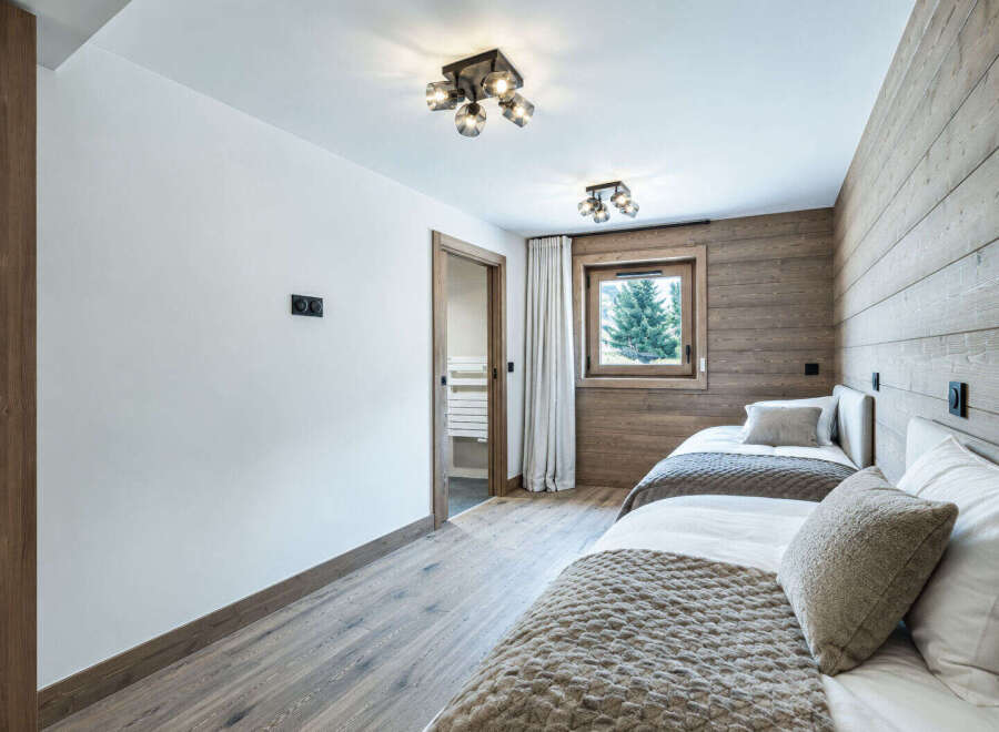 Experience cozy mountain living in this charming bedroom featuring two comfortable beds adorned with plush throws and pillows.