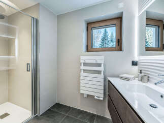 Experience modern luxury in this stunning bathroom, featuring a sleek glass shower enclosure and a spacious vanity with a clean white sink.