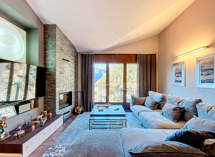Experience luxury living in this stunning property, featuring a modern living room with a cozy fireplace and a large flat-screen TV.