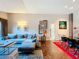 Discover modern living in this stylish property, featuring a spacious living area with a comfortable sectional sofa and a sleek coffee table.