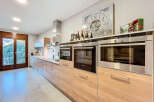 This modern kitchen boasts sleek, wooden cabinetry and state-of-the-art appliances, creating a stylish and functional space.