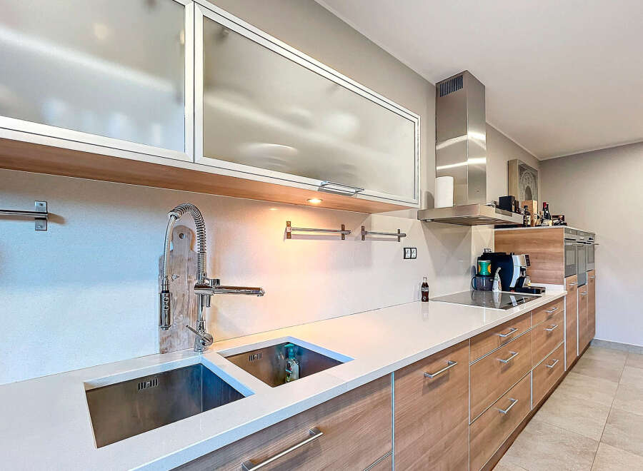 Modern kitchen design featuring sleek cabinetry, stainless steel appliances, and a pristine countertop.
